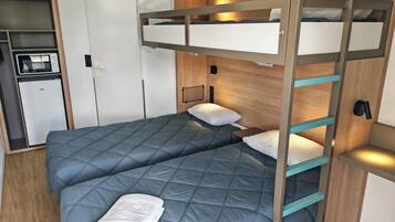 Una cama litera con una cama inferior y una superior, ambas con ropa de cama azul. Hay una toalla blanca sobre la cama inferior.