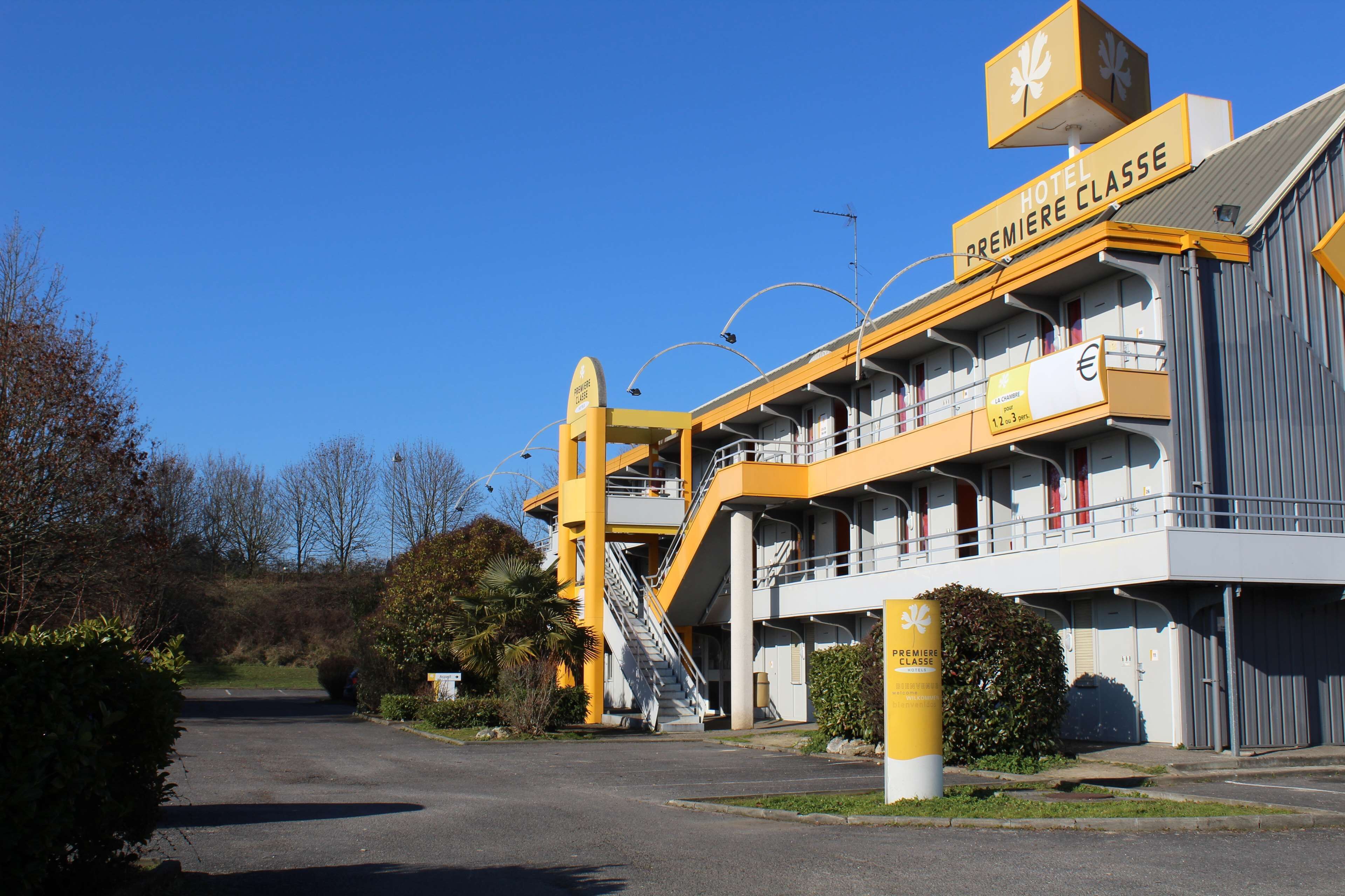 Ein Hotel mit gelb-weißer Fassade, mehreren Balkonen und einem Schild, das es als Hotel der Spitzenklasse kennzeichnet.