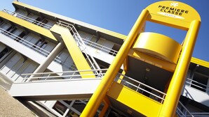 A yellow and white building with a sign reading "Premiere Classe Hotels".