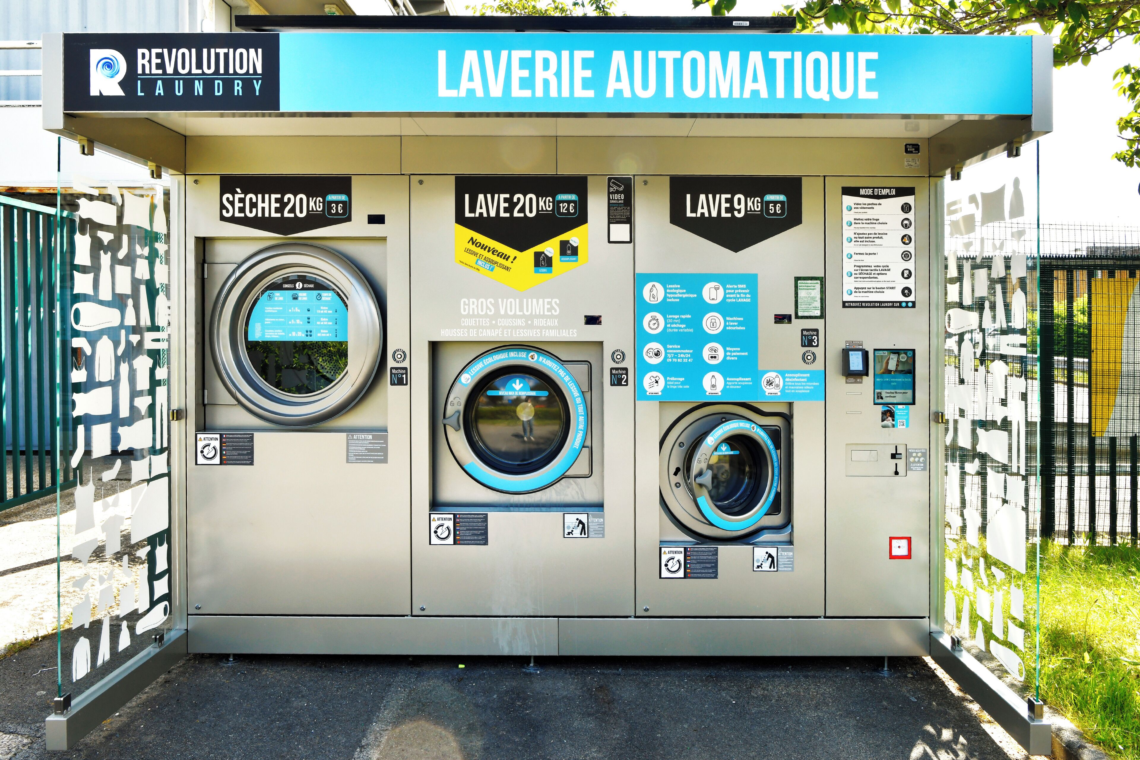 An automated laundry facility with three washing machines, each labeled with different capacities and prices.