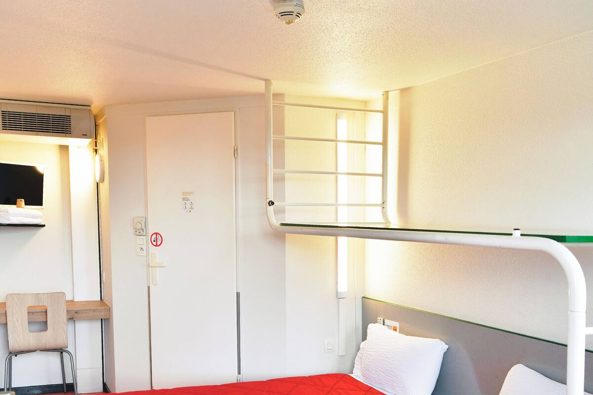 Une chambre avec deux lits, un bureau et une chaise.