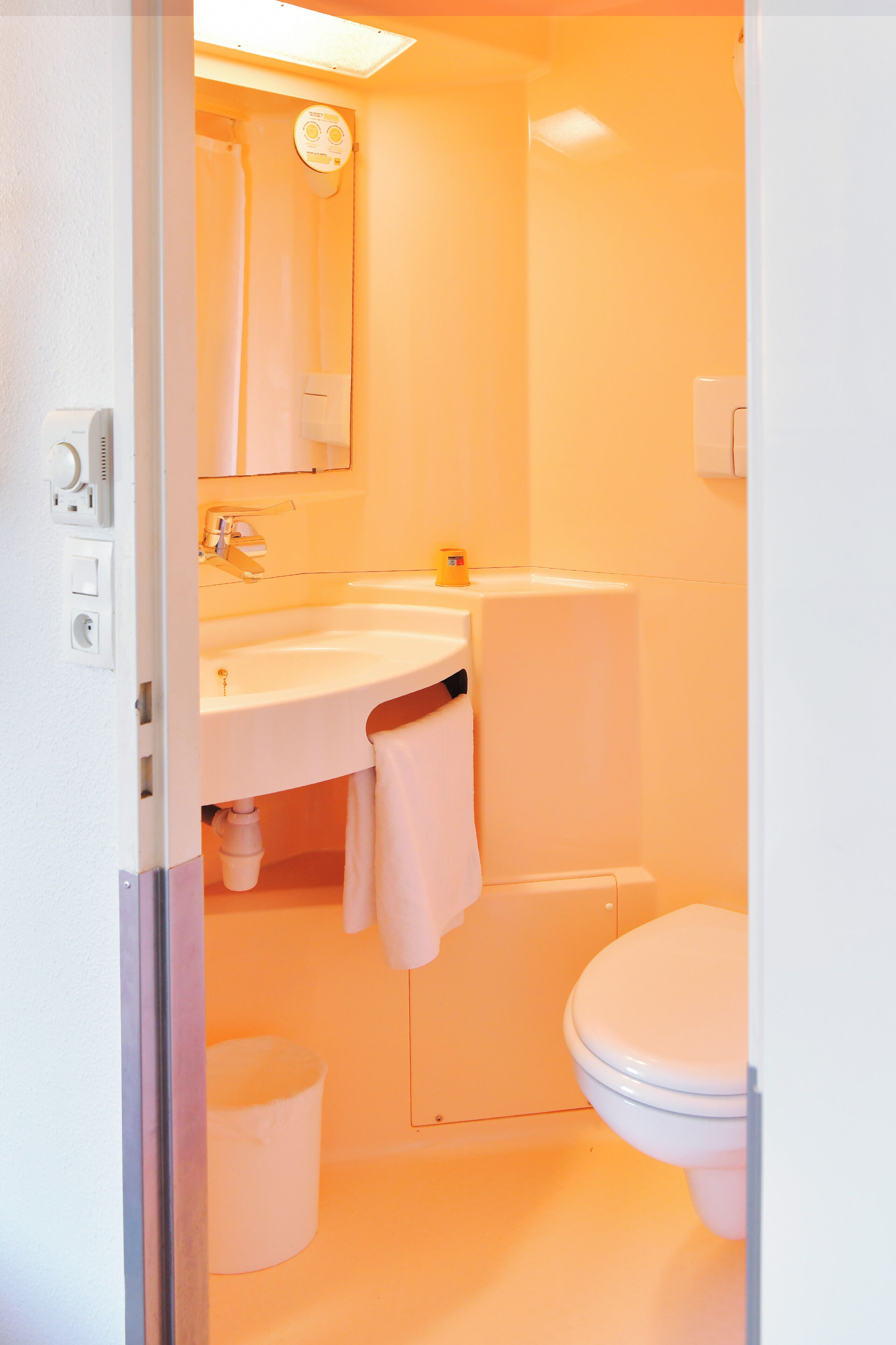 A bathroom with a white sink, mirror, and toilet.