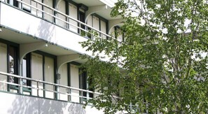 A multi-story building with balconies and large windows.