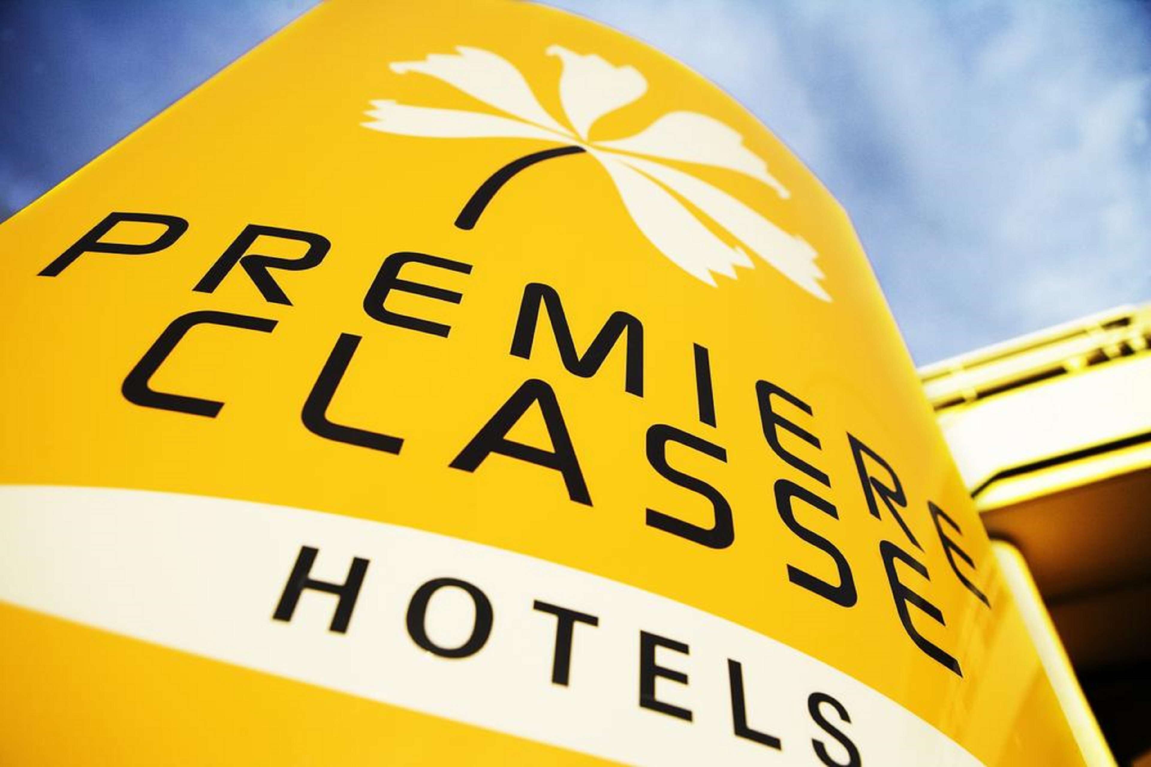 A yellow sign with "PREMIERE CLASSE HOTELS" written on it.