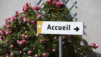 A sign with the word "Accueil" and an arrow pointing to the right, indicating the direction to the hotel.