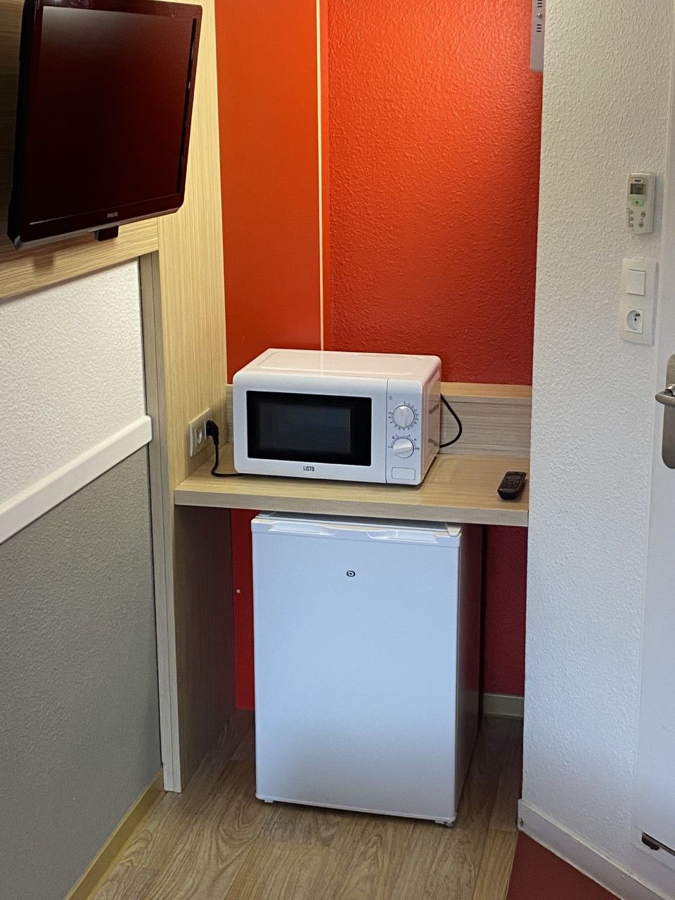 A compact kitchenette with a microwave and a mini-fridge.