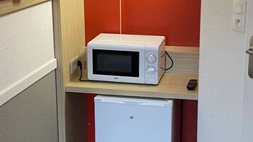 A compact kitchenette with a microwave and a mini-fridge.
