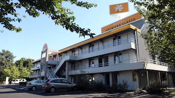 A hotel with a prominent sign reading "HOTEL PREMIERE CLASSE" and a staircase leading to the upper level.