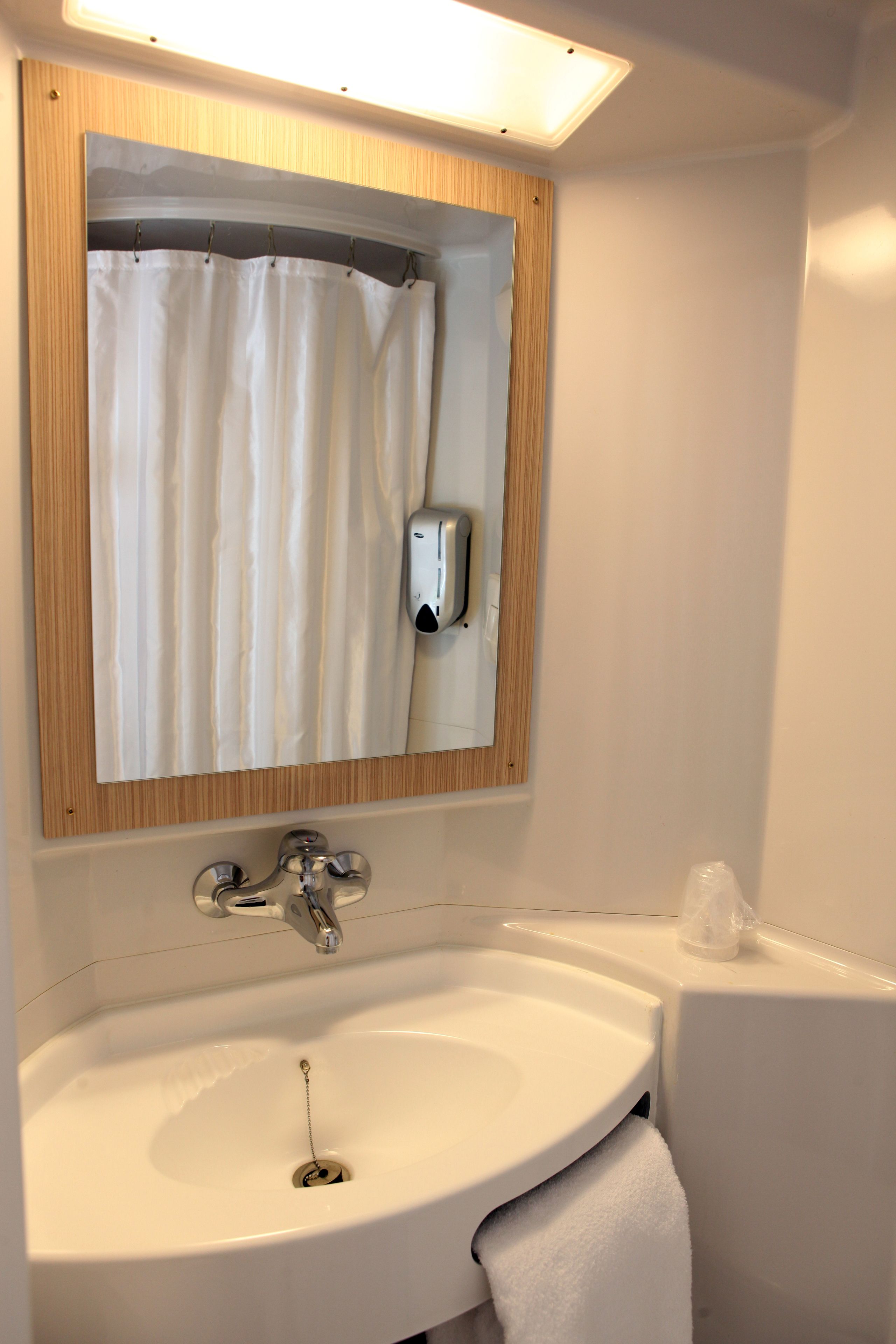A bathroom with a white sink, a mirror, and a shower curtain.