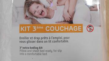 Un paquete etiquetado como "KIT 3ème COUCHAGE" con una descripción en francés que indica que es un juego de cama extra para la tercera cama, para un descanso confortable.