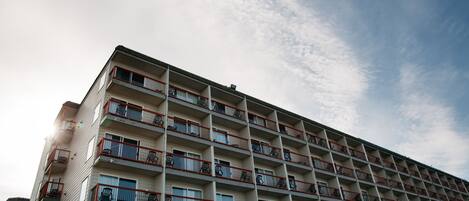 A multi-story hotel with balconies and a view of the sky.