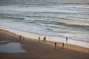 Une plage où des gens se promènent le long du rivage.