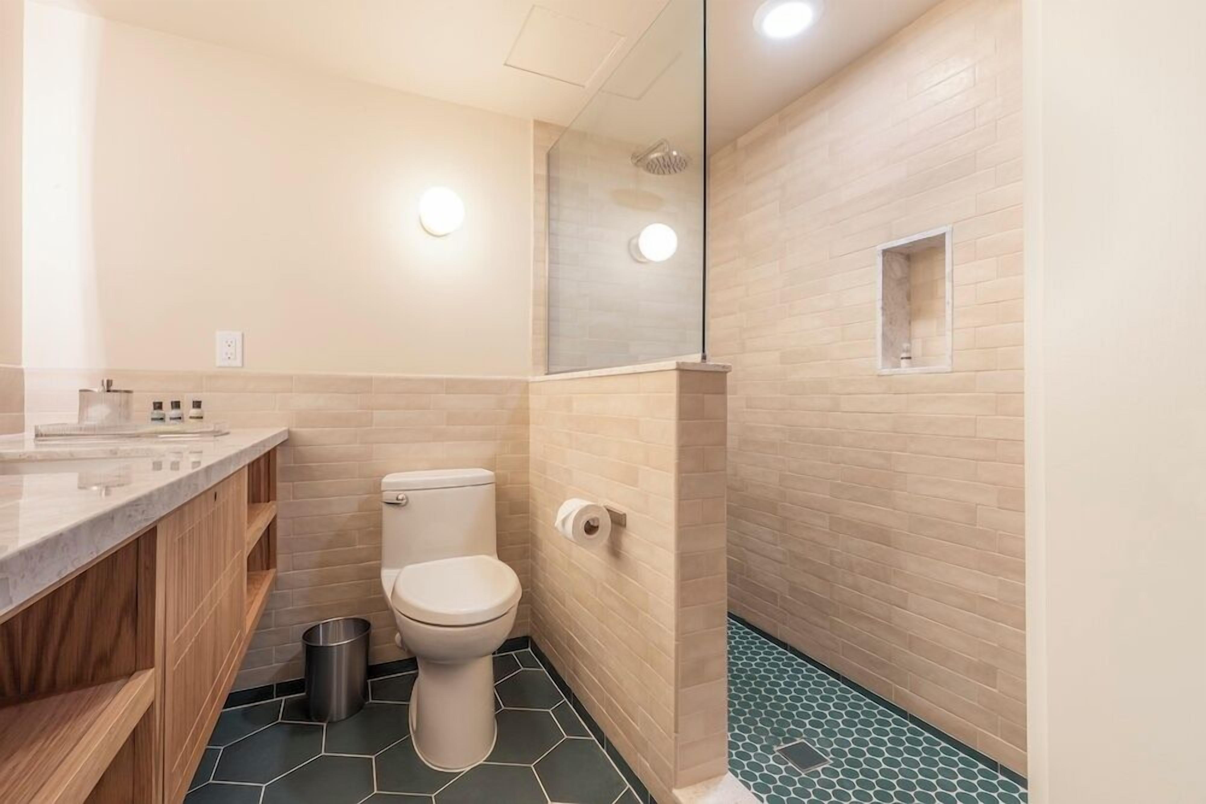 premium double queen | bathroom | combined shower/bathtub, eco-friendly toiletries, hair dryer, towels