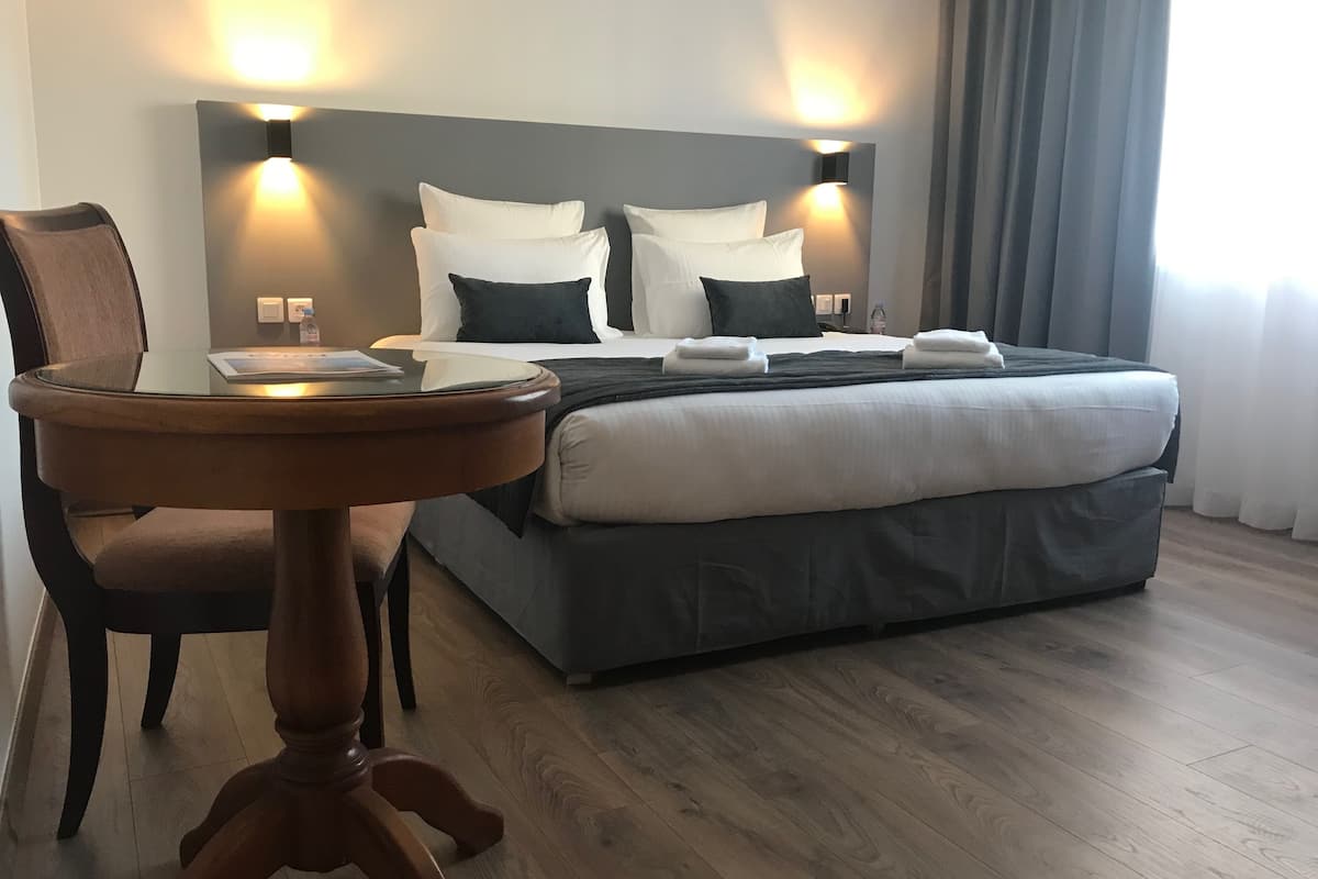 deluxe room lake view | premium bedding, in-room safe, desk, laptop workspace