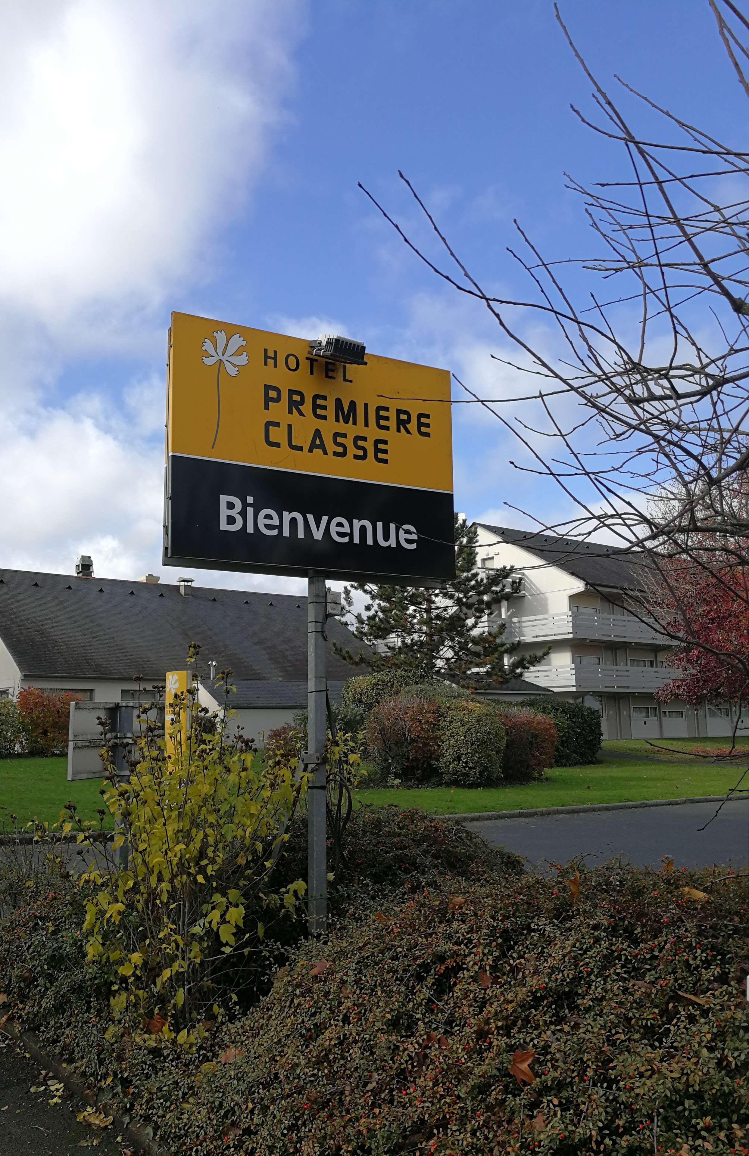 A sign for a hotel named 'HOTEL PREMIERE CLASSE' with a 'Bienvenue' greeting.