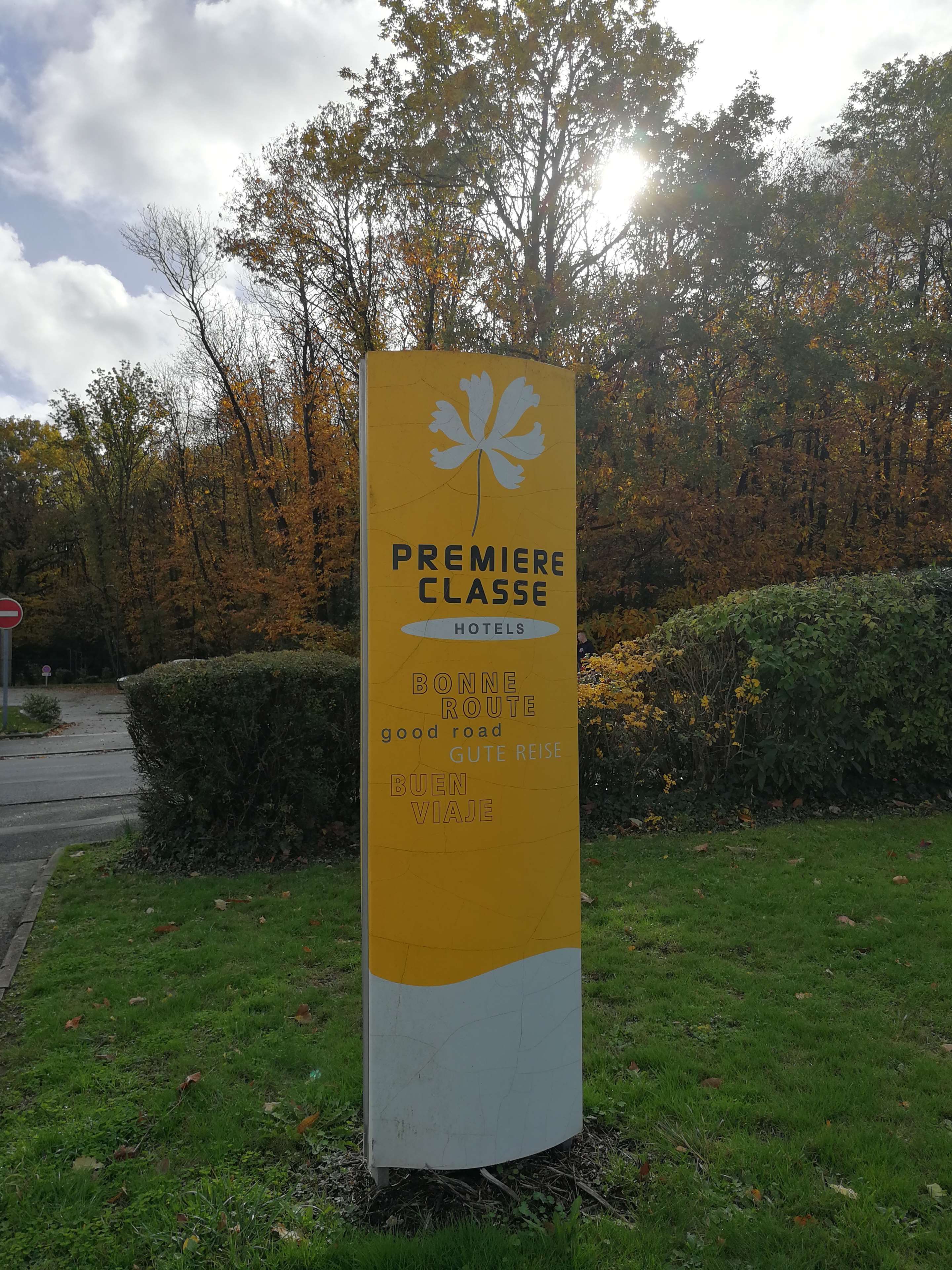 Señal de Premiere Classe Hotels con texto multilingüe que indica una buena carretera.