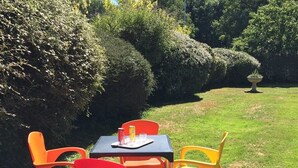 Une table avec quatre chaises, une nappe et une petite table sur laquelle se trouvent une boîte de conserve et un verre.