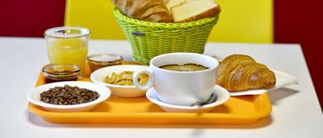 A breakfast tray with croissants, a cup of coffee, cereal, and a glass of juice.