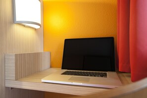 Work in comfort with a dedicated desk and wall-mounted lamp.