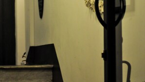 A staircase leading to a room with a door, a wall-mounted mirror, and a decorative plant. - Relais Palazzo Taverna (Rome)
