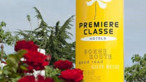 A yellow sign with the text "PREMIERE CLASSE HOTELS" and a white flower symbol. - Premiere Classe Tarbes - Bastillac (Tarbes)