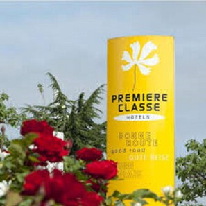 A yellow sign with the text "PREMIERE CLASSE HOTELS" and a white flower symbol.