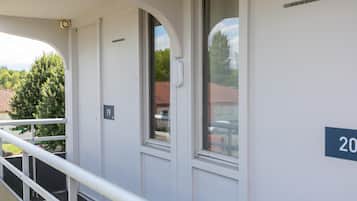 Ein Gebäude mit Balkon, einer Tür mit Klingelnummer und einem Fenster.