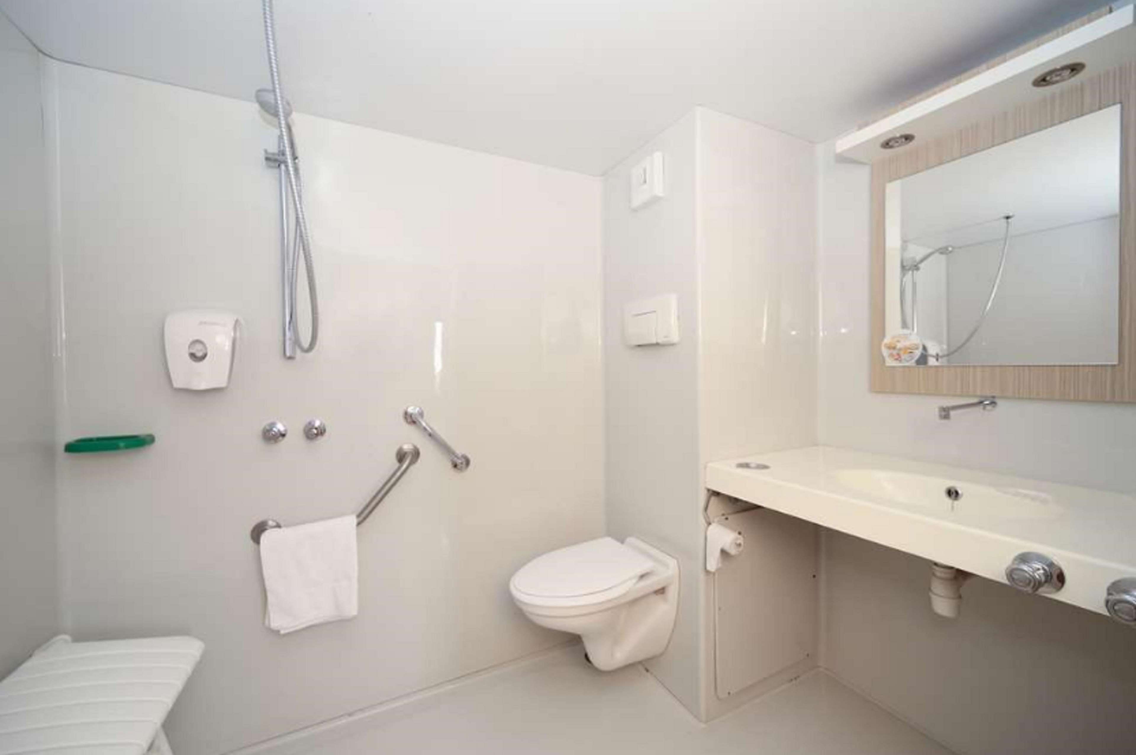 A modern bathroom with a toilet, sink, and shower.