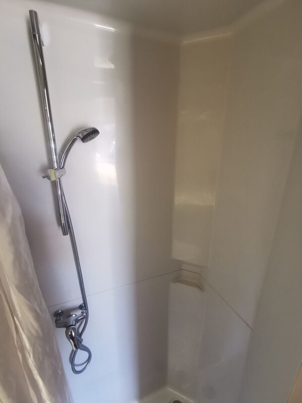 Ducha con cabezal de ducha de mano y grifo de mano.