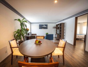Enjoy meals in this dining area with a round table and six chairs, a flat-screen TV, and a bookshelf.