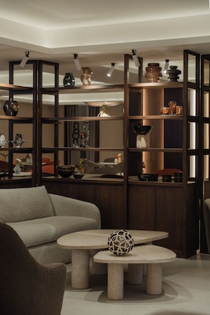 A modern interior with a sectional sofa, a coffee table, and a decorative sphere. - Suites Obelisk (Mexico City)