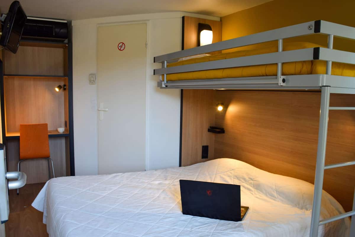 Ein Stockbett mit einem Laptop auf der unteren Etage.