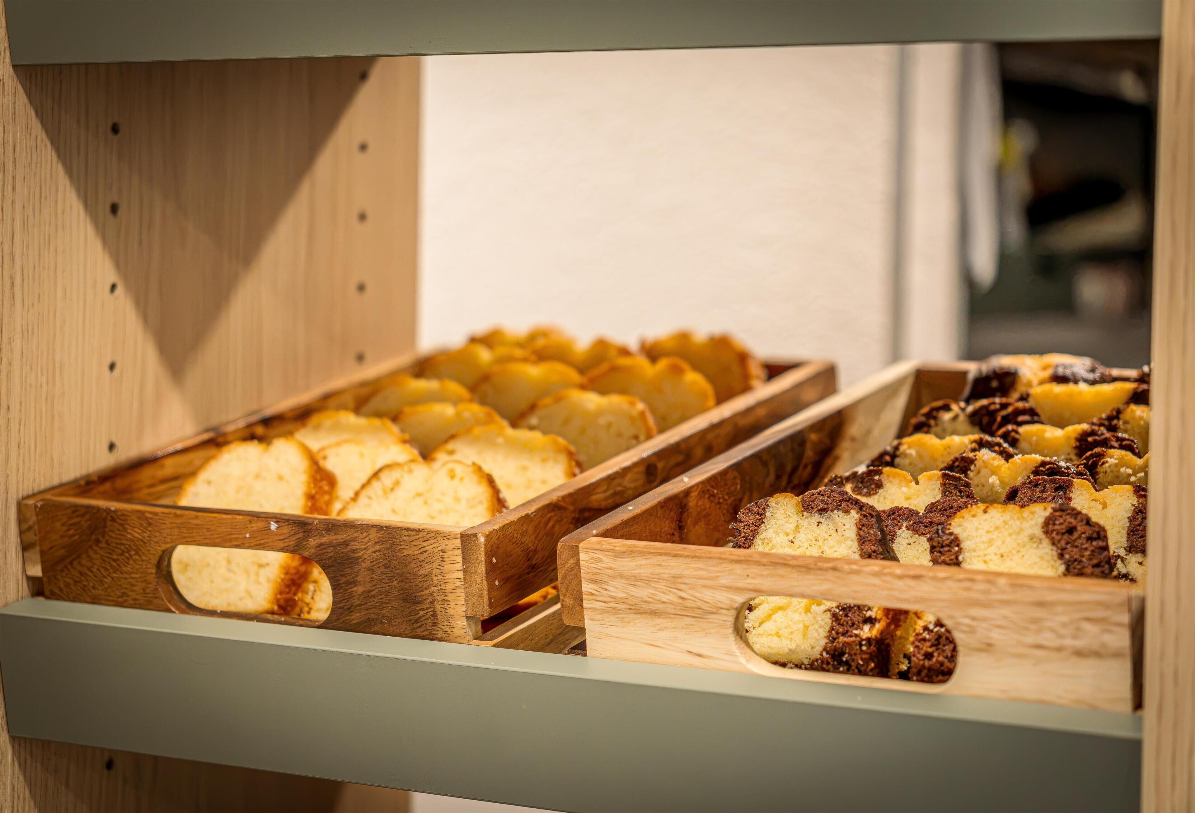 A wooden display case with two trays of baked goods.