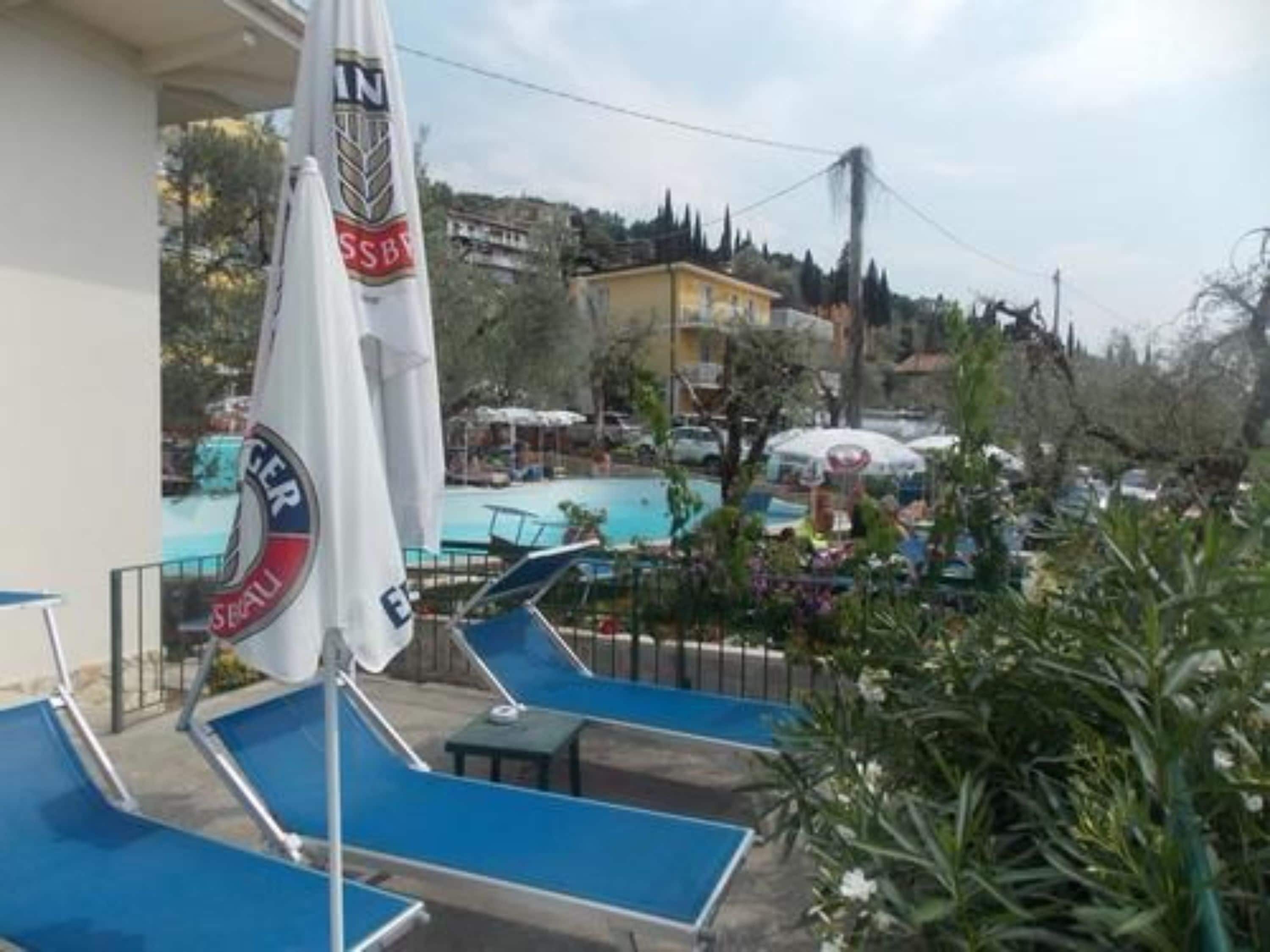 Ein Poolbereich mit Liegestühlen und einer Flagge.