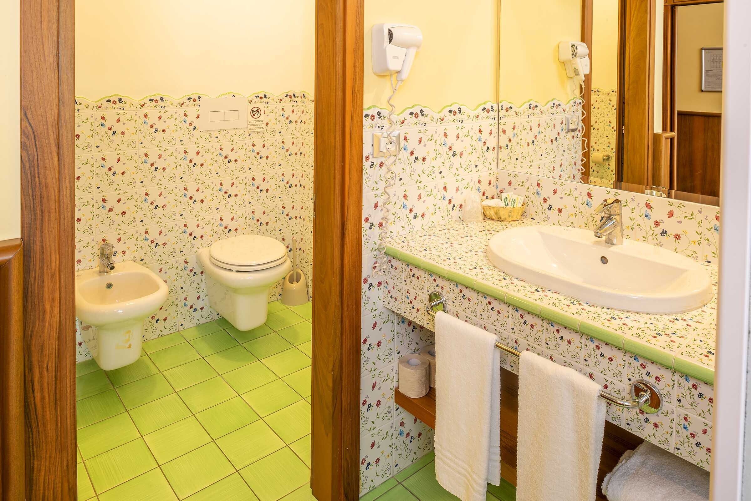 A bathroom with a toilet, bidet, and sink.