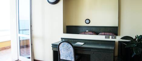Habitación de hotel con escritorio, silla y un espejo grande en la pared.