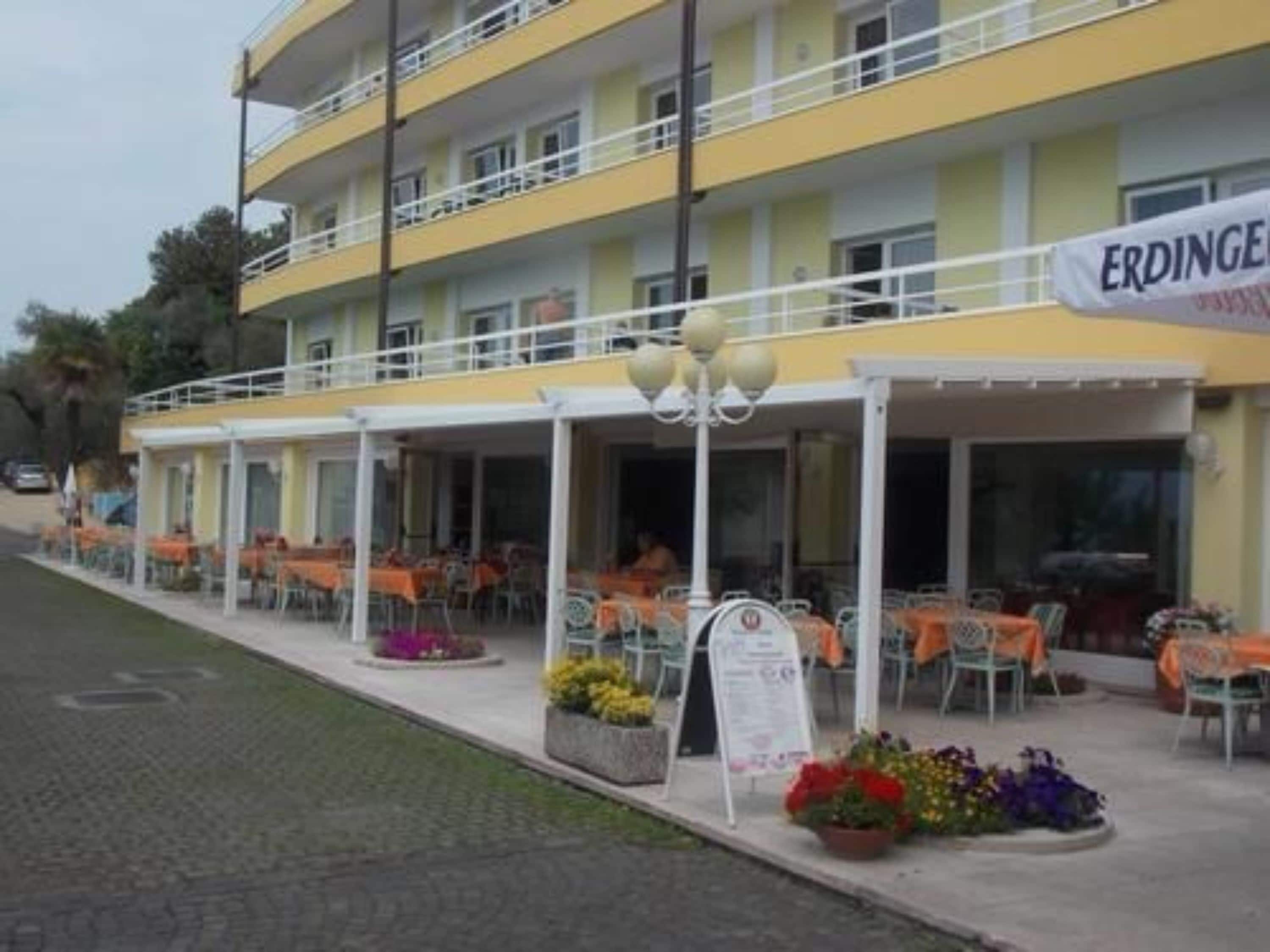 A multi-story hotel with outdoor seating and a sign reading "ERDINGER."
