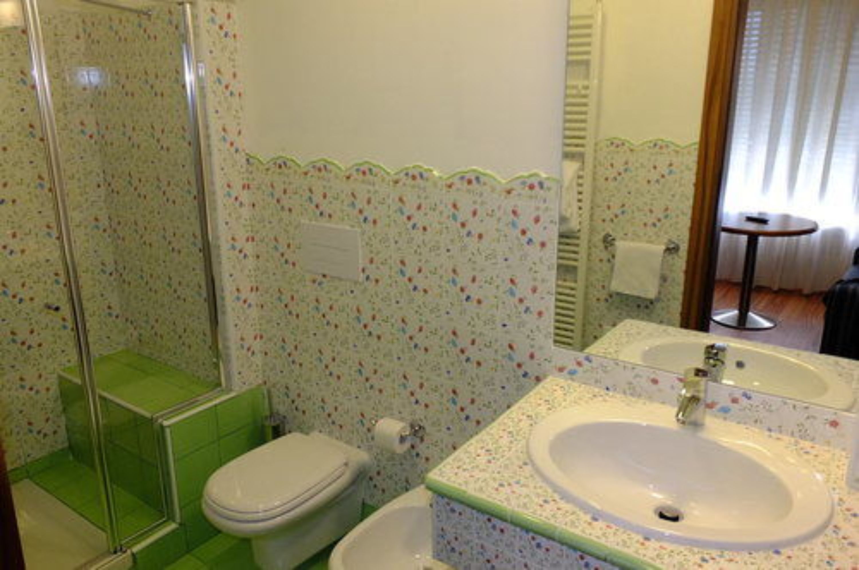 A bathroom with a shower, toilet, and sink.