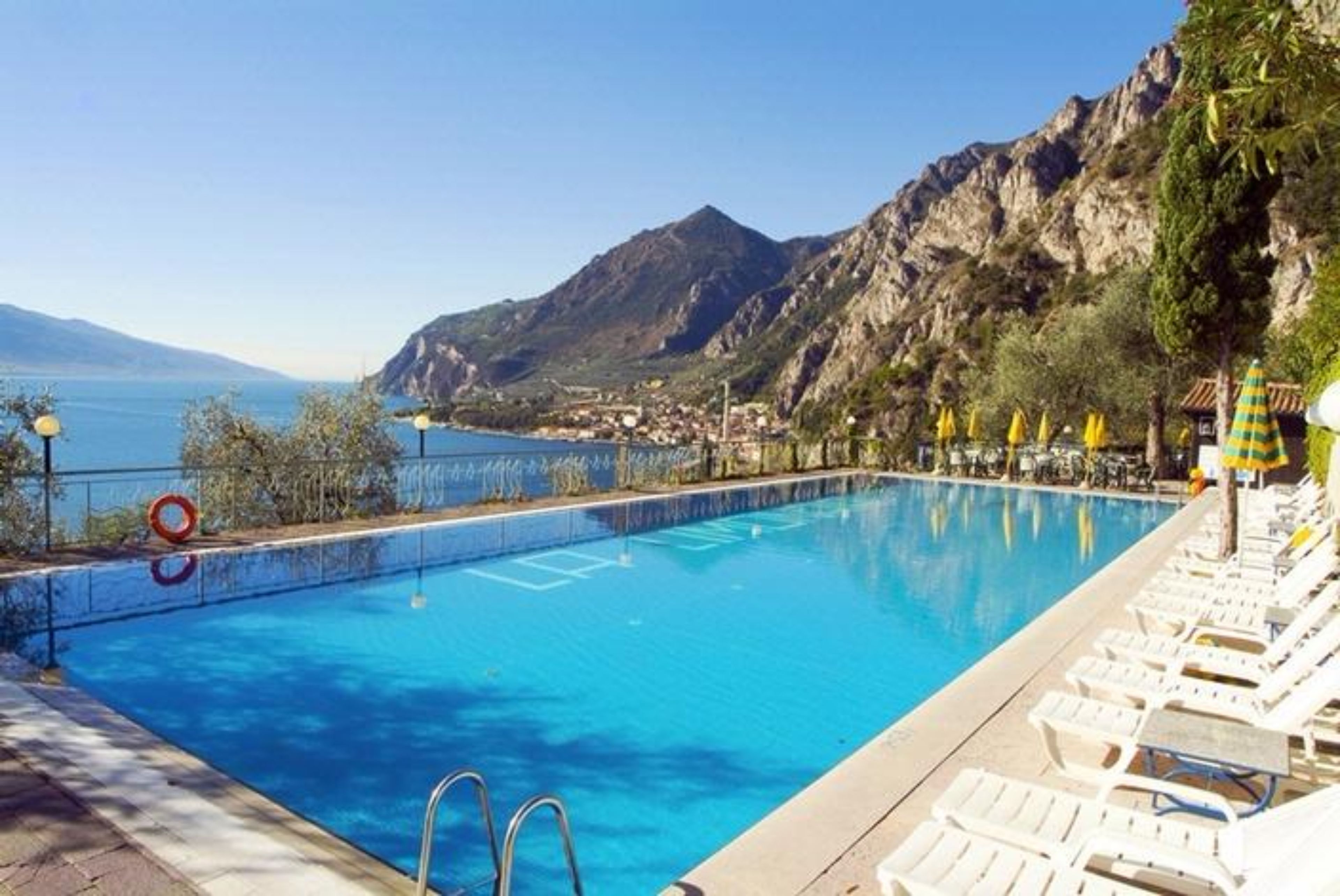 A swimming pool with a view of the sea and mountains.