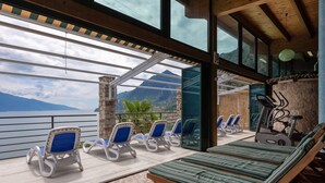 A sunlit lounge area with a view of a mountain and a body of water.