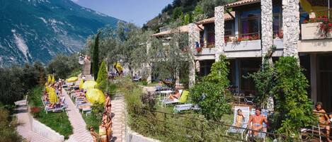 A hillside hotel with outdoor seating and a mountain view.