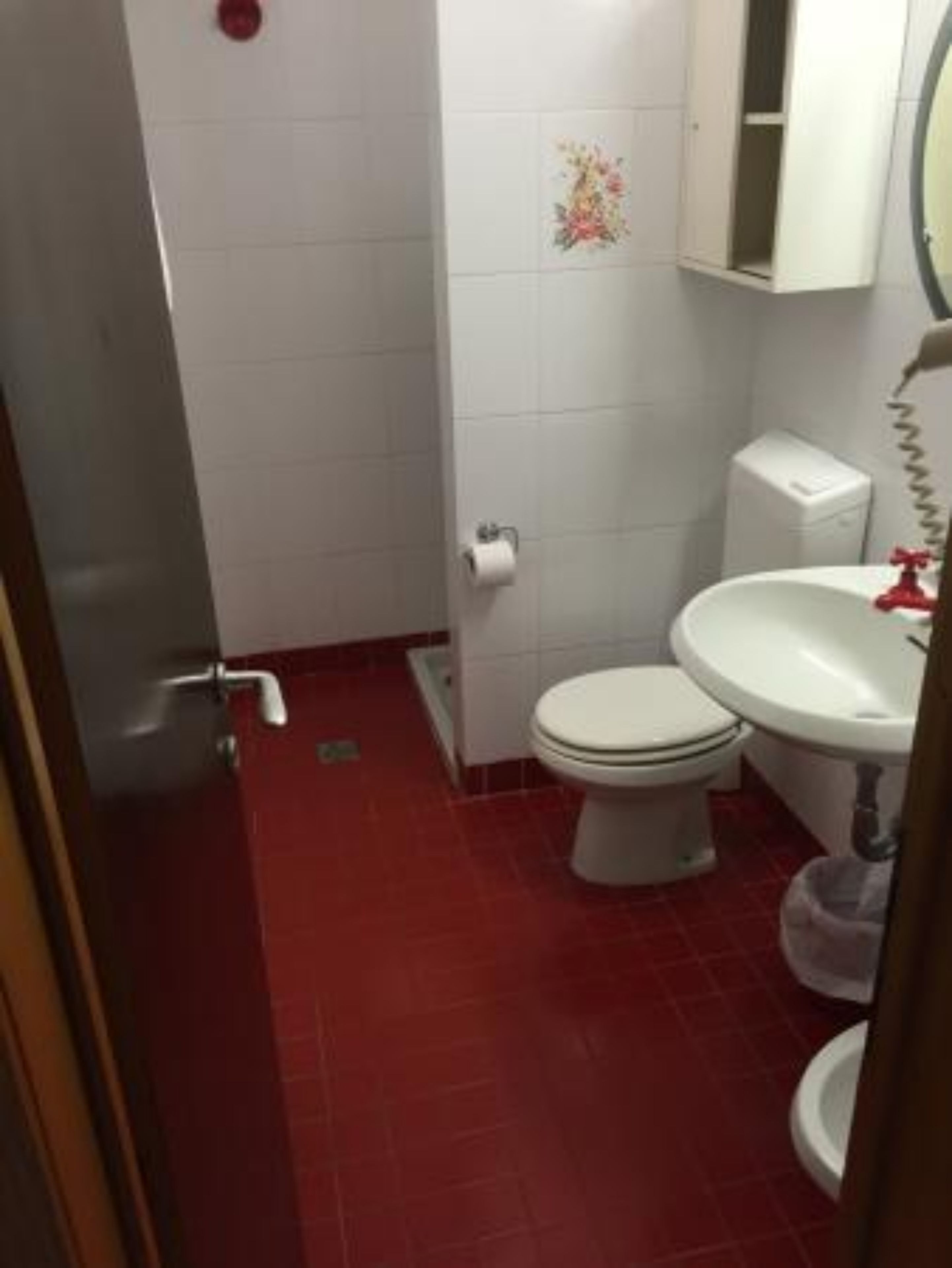 Une petite salle de bain comprenant des toilettes, un lavabo et un meuble au-dessus du lavabo.