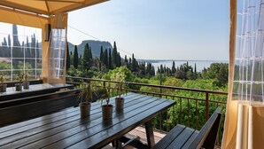 A wooden table with potted plants and a view of a mountainous landscape. - Hotel Marco Polo (Garda)