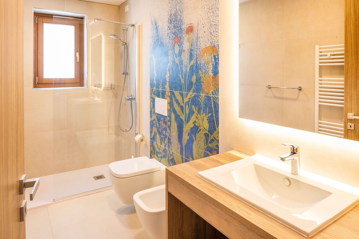 A modern bathroom with a shower, toilet, and sink.