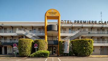 Entrada de un hotel con un arco amarillo destacado que indica 'Premiere Classe Hotels'.