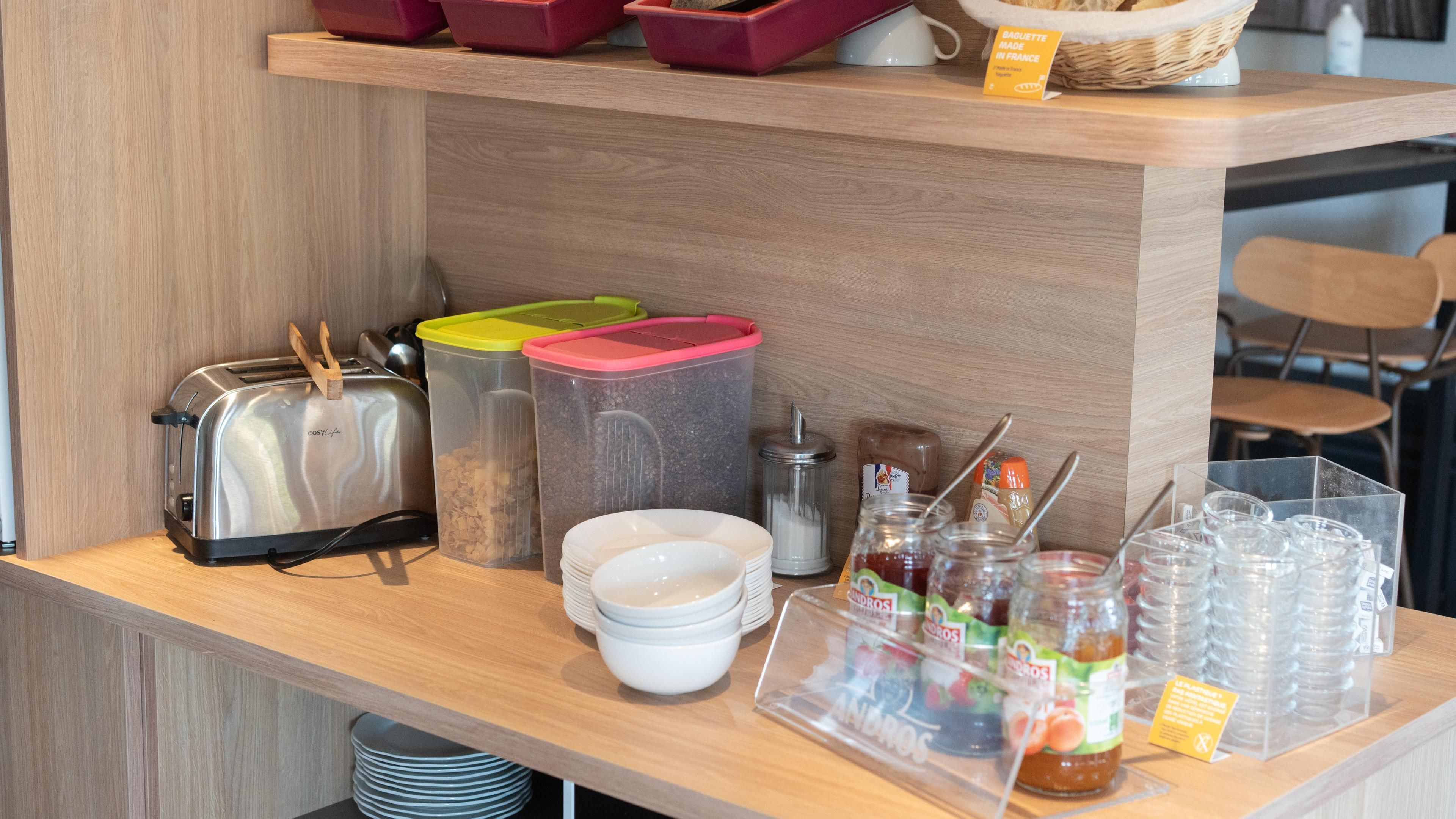 Un bar pour prendre le petit-déjeuner, équipé d’un grille-pain, de récipients, de bols et de condiments.