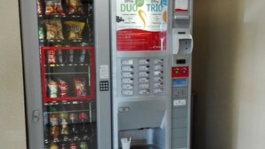 A vending machine with various snack options and a coffee dispenser. - Premiere Classe Limoges Nord (Limoges)