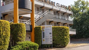 A building with a sign reading 'Première Classe' and a welcome sign with amenities listed. - Premiere Classe Limoges Nord (Limoges)