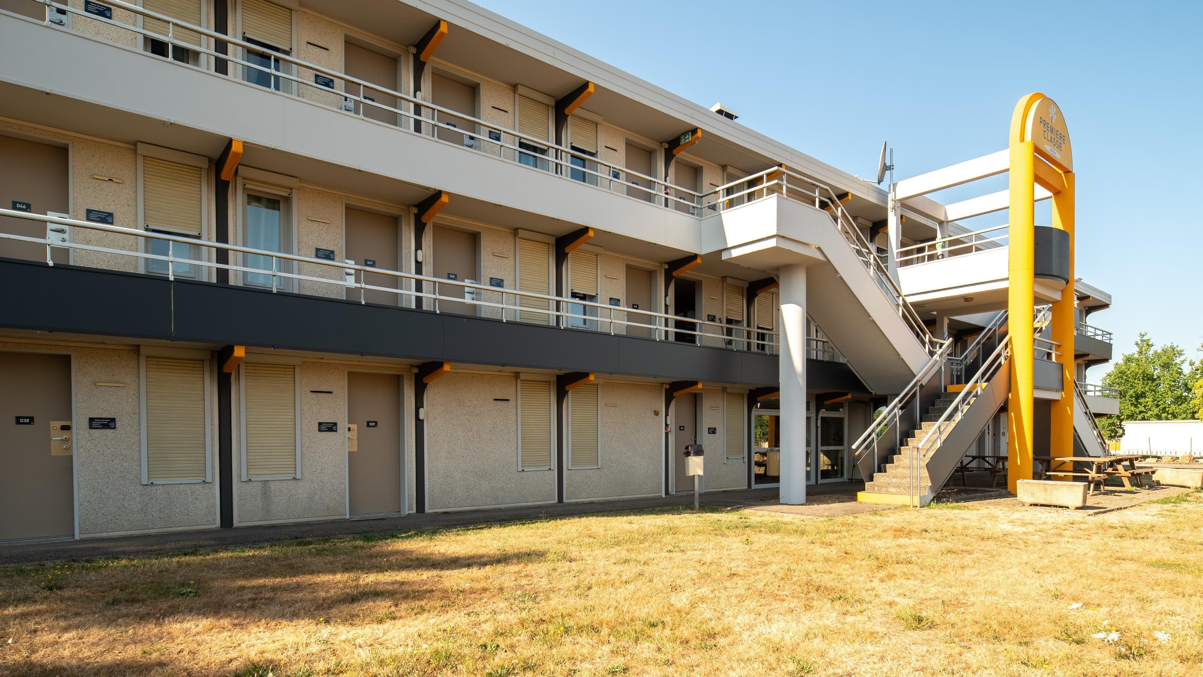 A multi-story building with a central staircase and a balcony on the upper floor.