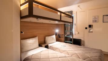 Una camera da letto con due letti, una testiera in legno e una piccola scrivania.